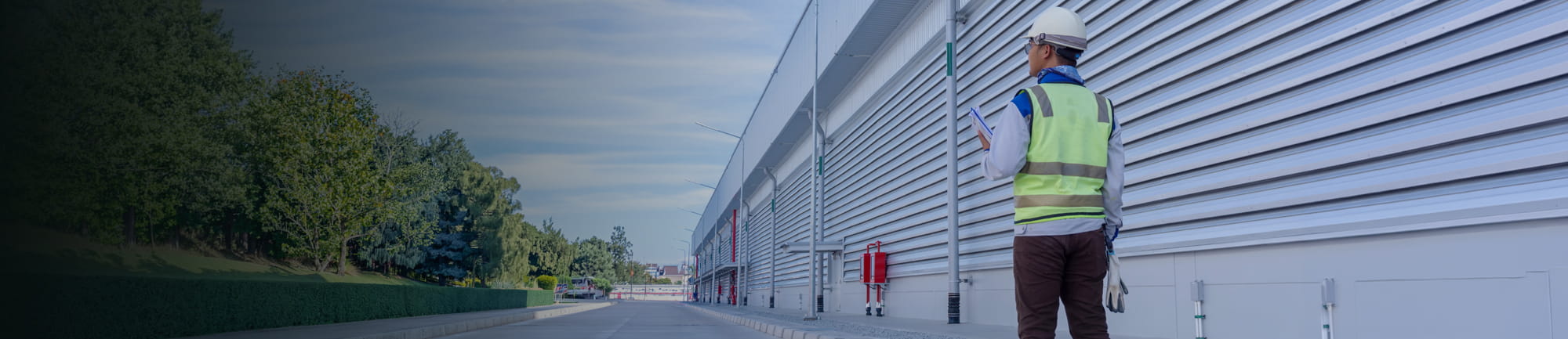 Man in hard hat standing next to large building