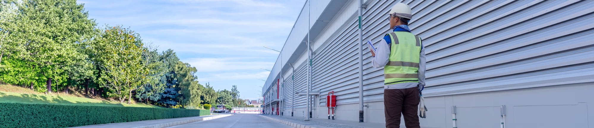 Man in hard hat standing outside large commercial building