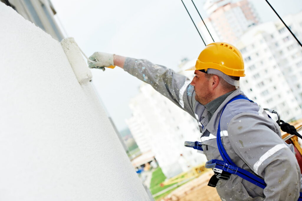 Man in hard hat painting wall